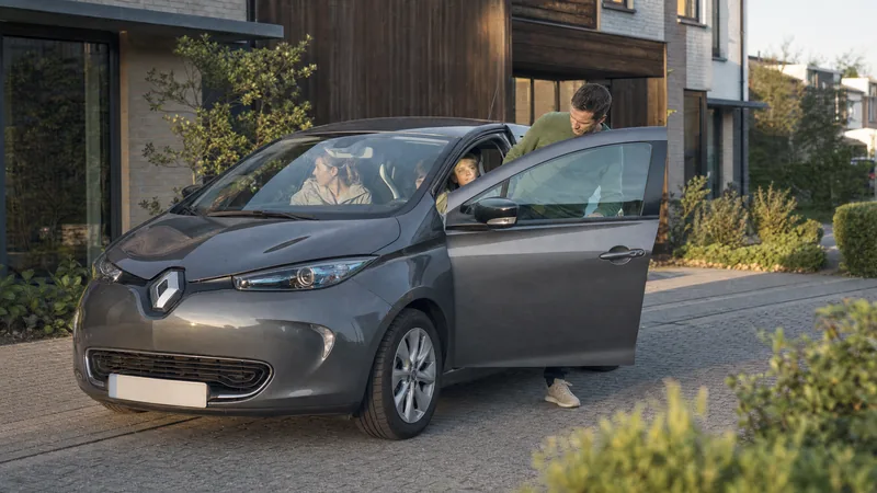 Een gezin bij de open koffer van een elektrische wagen voor hun woning